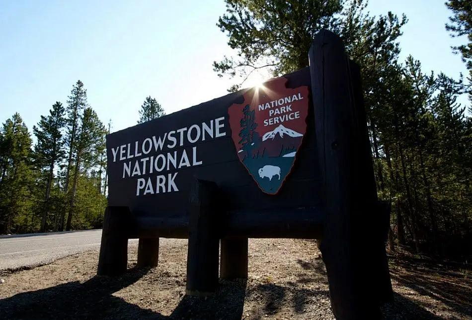 Wooden Yellowstone National Park entrance sign with National Park Service logo on Pacific Coast Highway