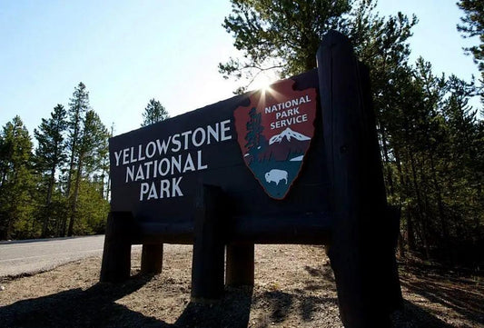 Wooden Yellowstone National Park entrance sign with National Park Service logo on Pacific Coast Highway